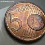Part of a bedbug next to a Euro Cent